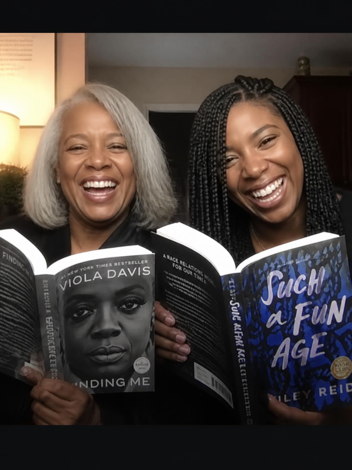 Two women reading a book together during Book Club